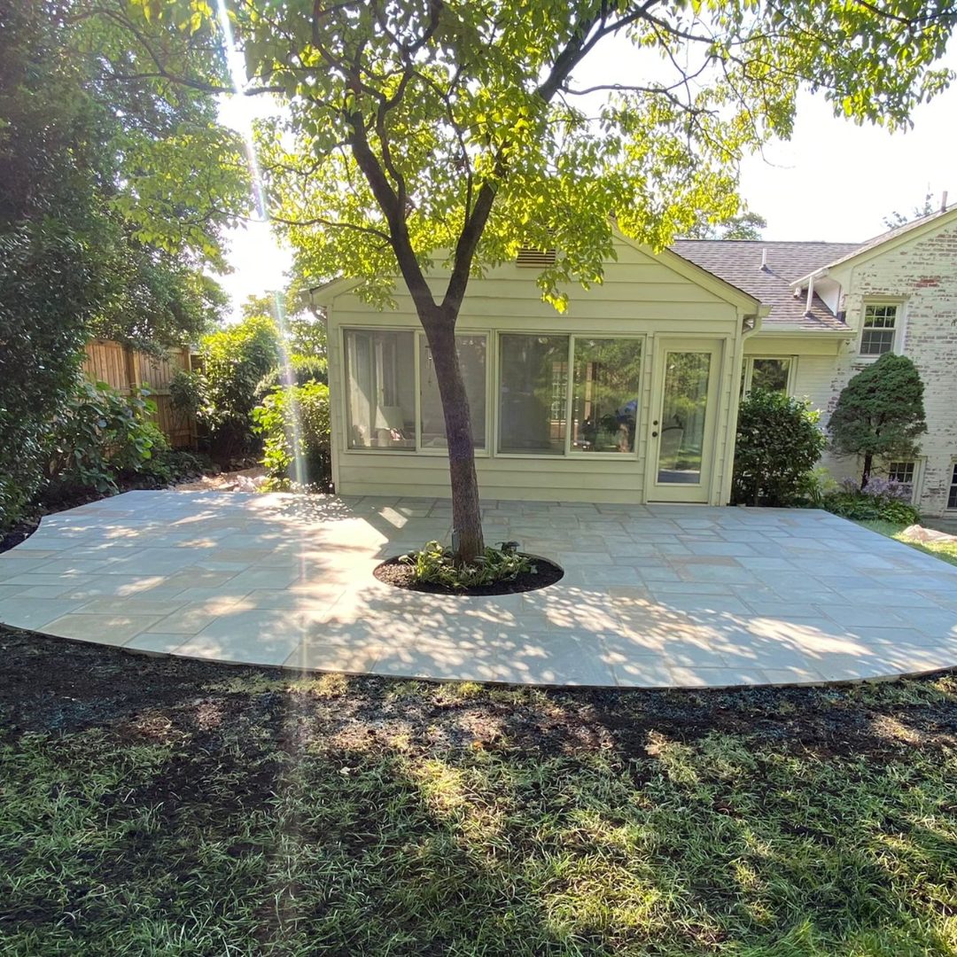Stone patio with tree in center.