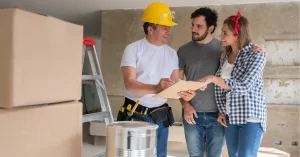 Homeowners meeting with bathroom remodel contractor reviewing renovation plans and discussing project details