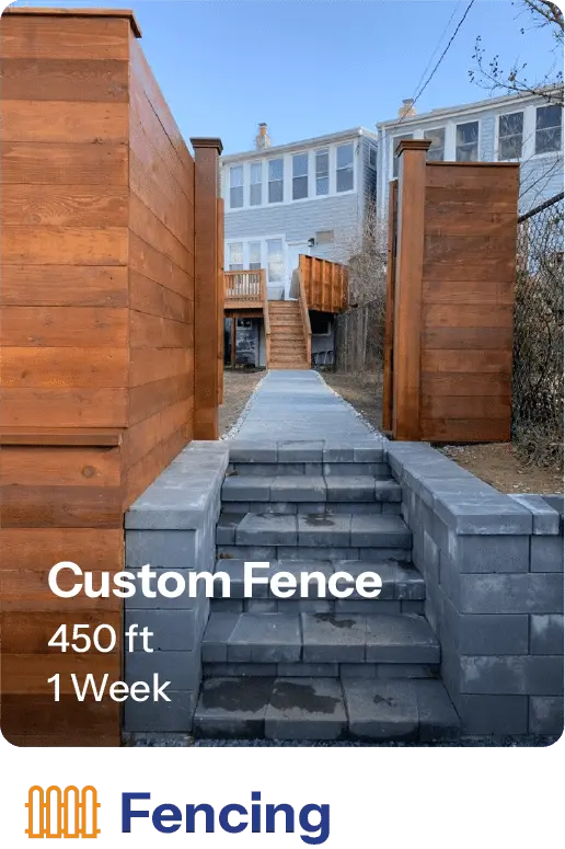 Custom wooden fence installation with a 450-foot length, completed in one week. The image showcases a pathway leading to a house, bordered by tall wooden panels, enhancing outdoor aesthetics and privacy.