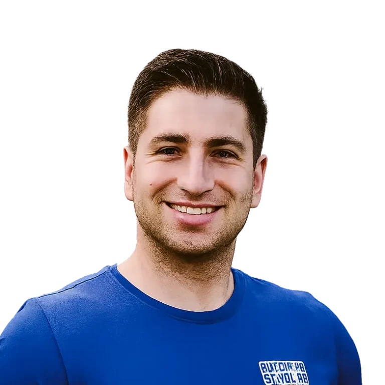 Smiling person wearing a blue shirt against a black background.