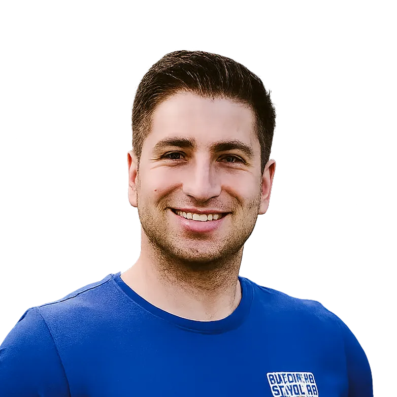 Smiling person wearing a blue shirt against a black background.