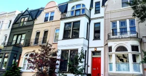 Row of colorful European-style townhouses with distinct architectural details.