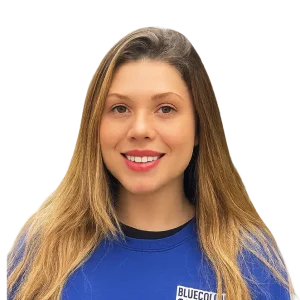 Laura is smiling in a blue shirt against a plain background.