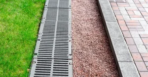 Surface drainage system guide showing linear channel drain protecting homeowners property from water damage and flooding