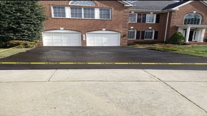 Brick house with a new asphalt driveway and yellow caution tape across it.