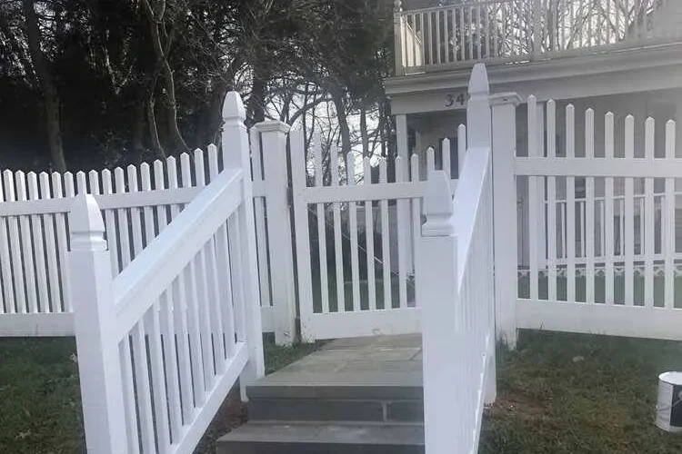 Gate Ideas: Stone steps lead up to a white picket fence and gate, with trees in the background.