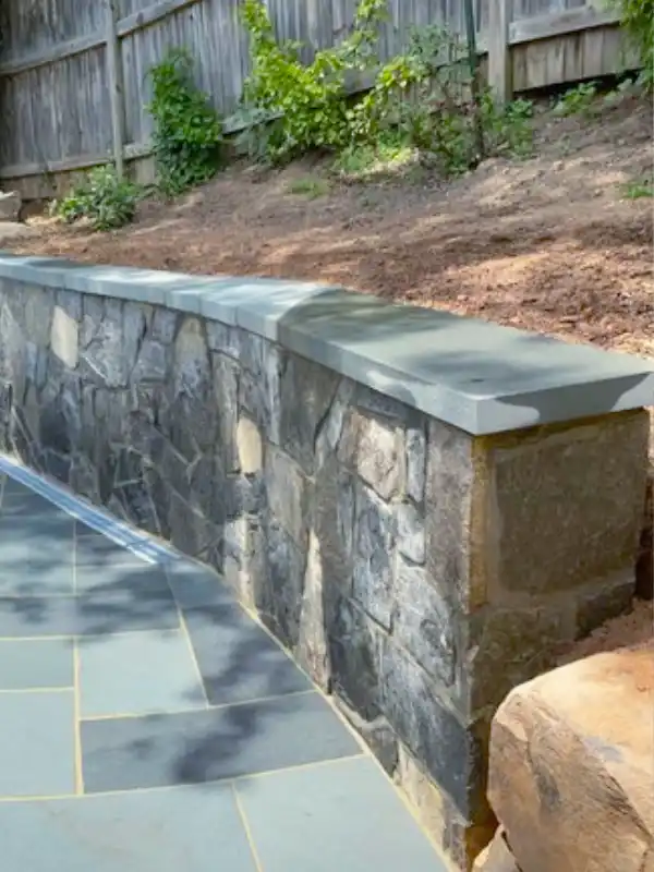 Hardscape installation in Montgomery County, MD showing a Flagstone Patio with a Retaining Wall by Blue Collar Scholars.