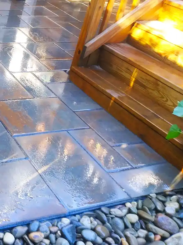 Complete hardscaping project showcasing a thermal bluestone next to a wooden staircase and a river gravel swale