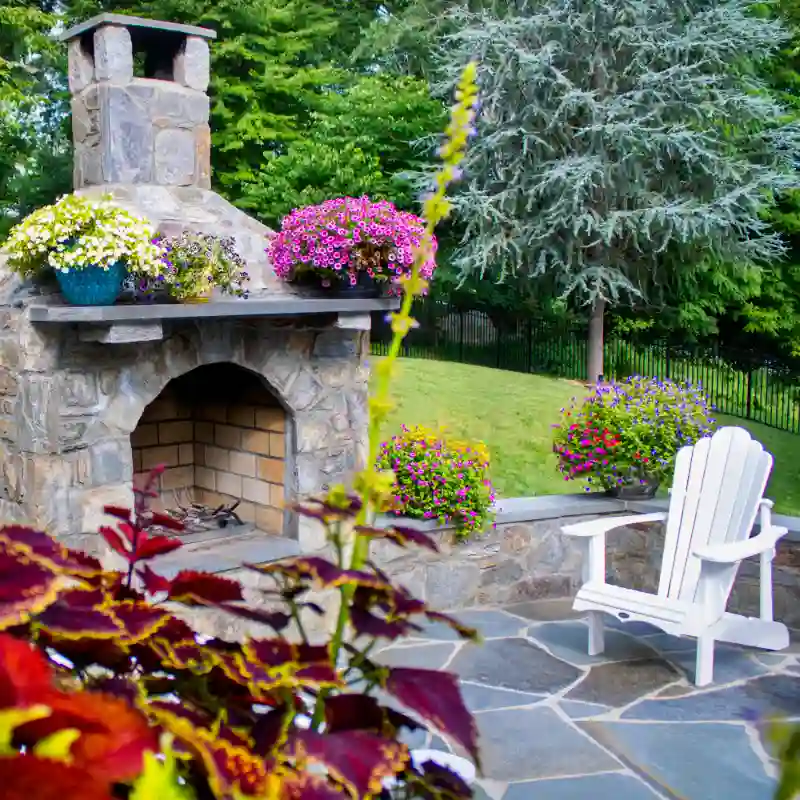Outdoor living space showcasing a flagstone patio with a fire pit and a colorful landscape design
