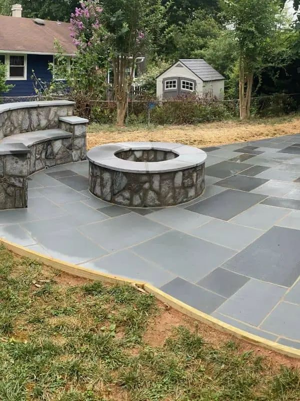 paver patio with a retaining wall and fire pit