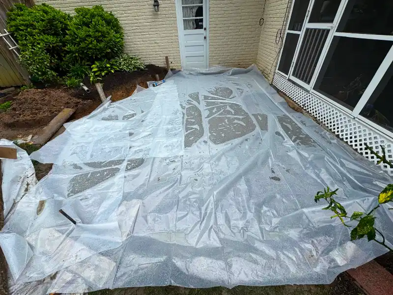 Backyard patio area covered with plastic sheeting during ground preparation and site protection
