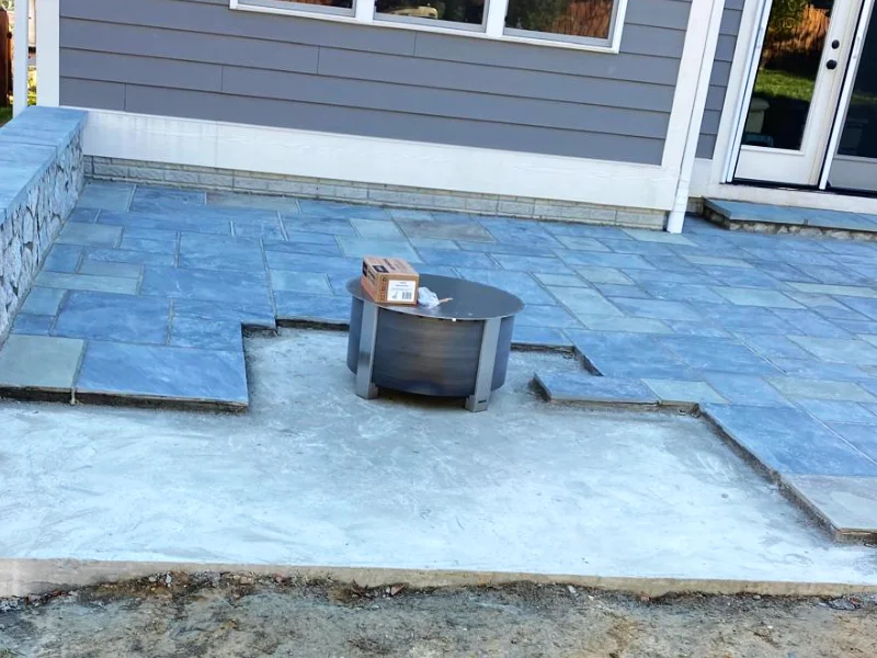 Circular fire pit block core under construction with flagstone cut to fit around base