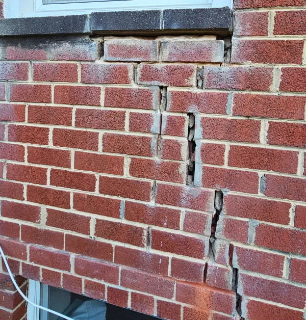 Stair-step mortar joint cracking on exterior brick wall before repair in Temple Hills, MD