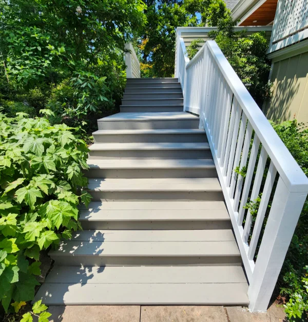 Finished rebuilt deck stairs with white railings at home in McLean VA