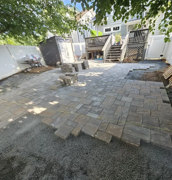 placing the paver stones one by one to ensure that it fits the backyard and client design