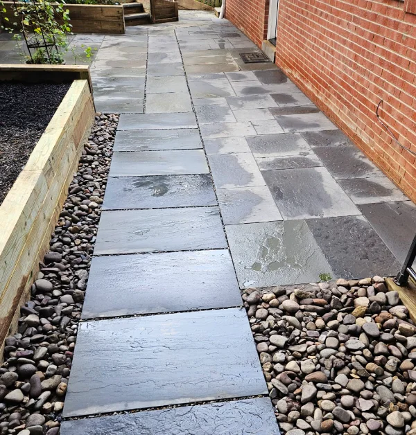newly installed flagstone walkway leading to a patio with a french drain system