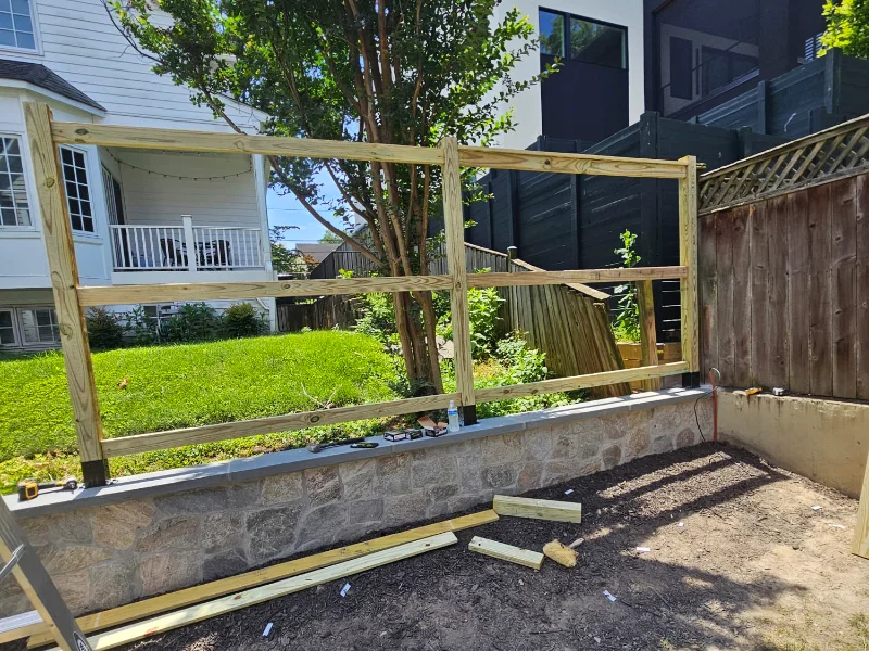 Privacy fence framing installed above retaining wall