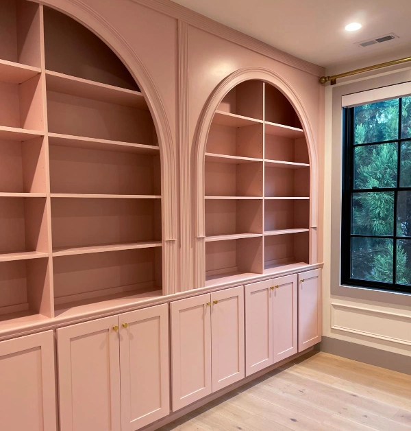 Custom floor-to-ceiling home office built-ins with three arched bookshelves, lower storage cabinets, decorative trim work, and integrated millwork installed during a bedroom-to-office remodel in McLean, VA.