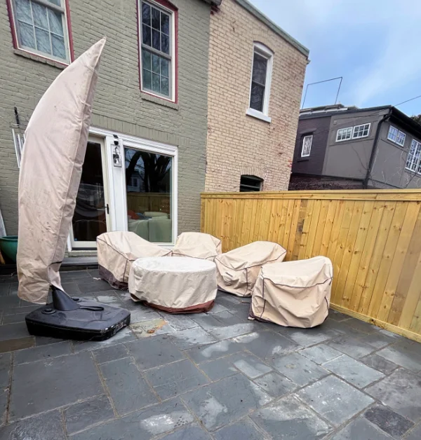 completed flagstone patio with wooden privacy fence with furniture