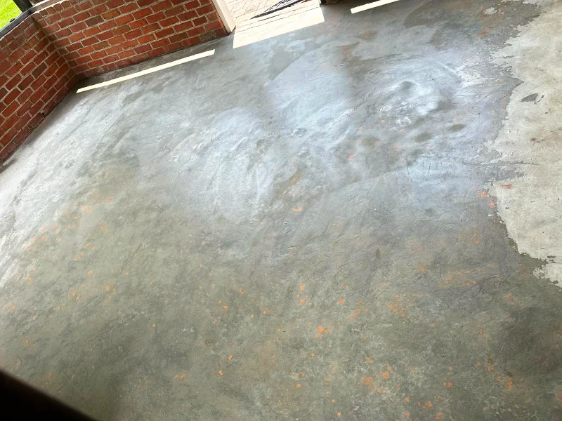 Concrete skim coat across the existing porch slab to create a smooth, uniform surface.