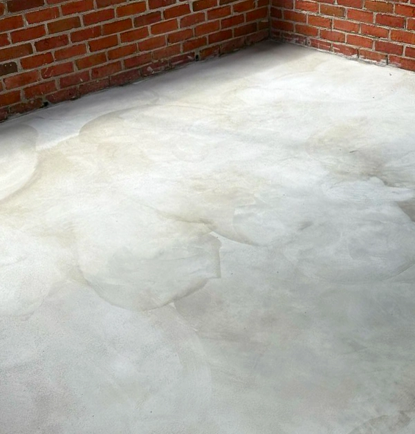 Finished concrete porch floor after resurfacing with a smooth natural gray skim coat inside a covered backyard porch in Rockville, MD.