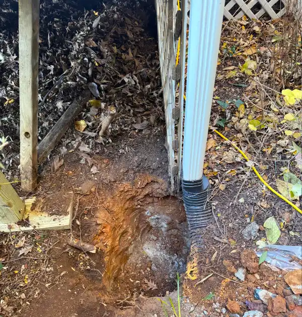Original porch corner before repairs showing the existing support post, downspout, and electrical components prior to structural work.