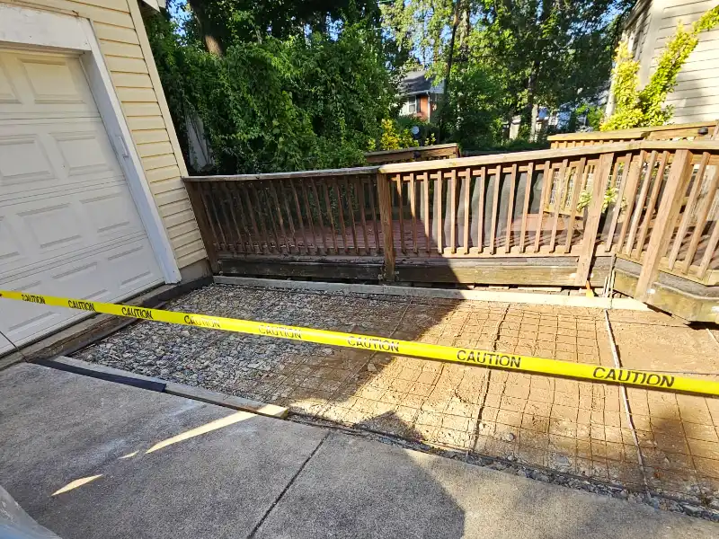 Excavated driveway section with gravel base and steel reinforcement prepared for new concrete installation