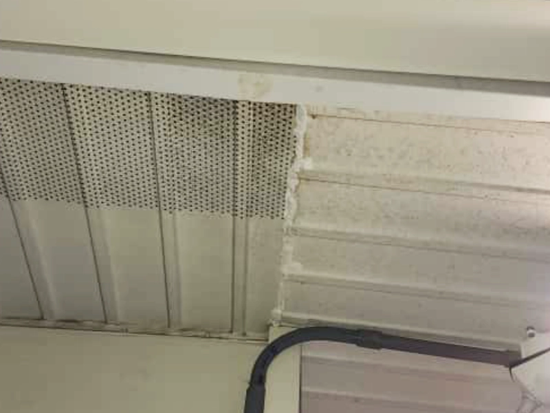 A clean line of weather-resistant white silicone caulk sealing a one-foot gap in the white vinyl soffit siding at a roofline corner intersection.