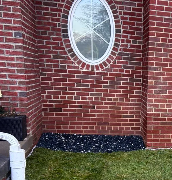 Finished exterior foundation waterproofing project with restored Tall Fescue sod, improved drainage, and protected basement window well areas at a home in Silver Spring, Maryland.