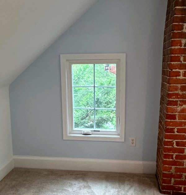 Newly installed white casement egress window with painted trim on the exterior of a historic home in Kensington, MD.