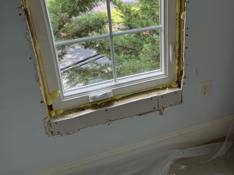 Window replacement in progress showing the newly installed unit before interior finishing and painting.