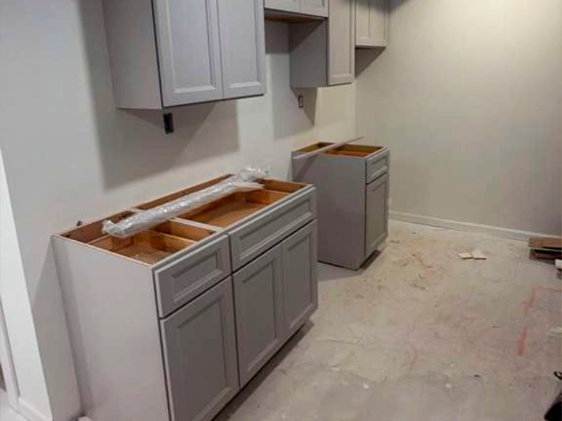 Side view of newly installed kitchen cabinetry before the final fixtures, countertops, and finishing details were added.