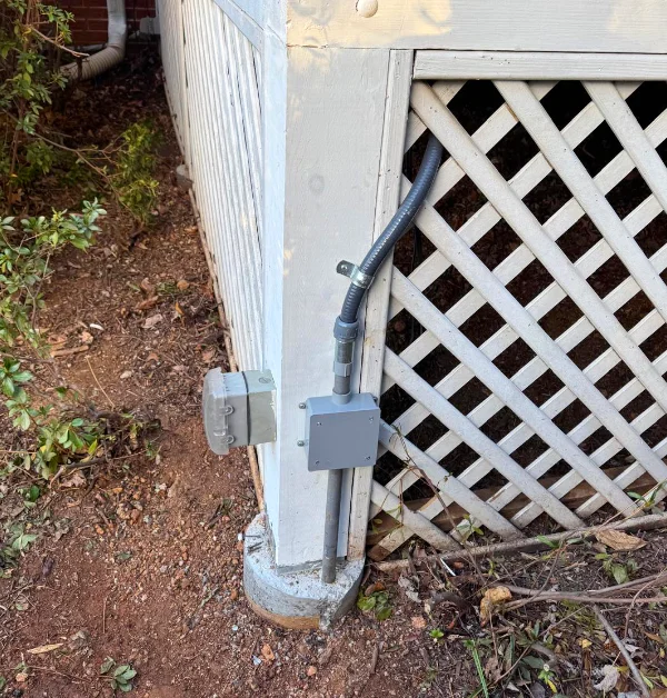 New pressure-treated porch support post installed on a concrete footing beneath a raised screened porch after structural repairs were completed.