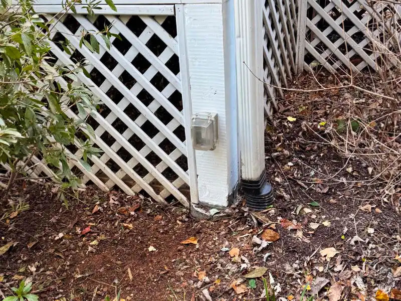 Completed corner of the raised screened porch with a new painted support post and restored structural support.