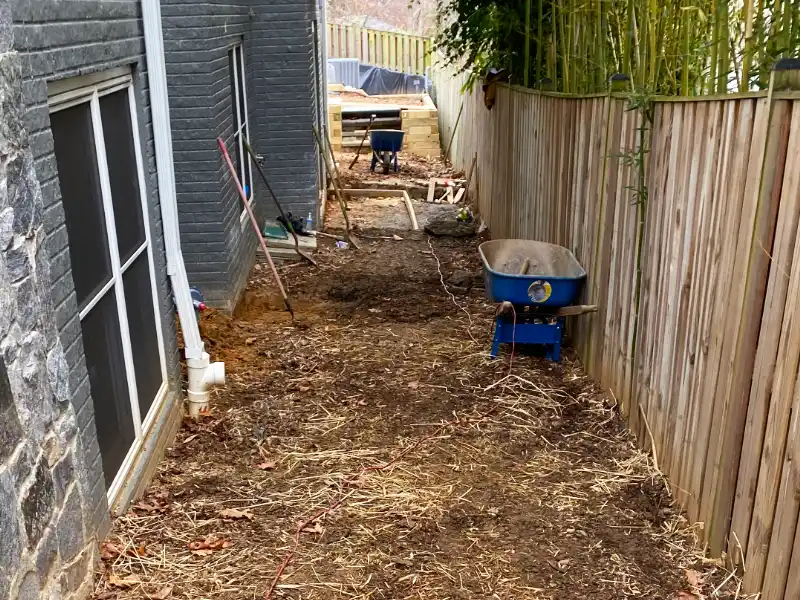 Side yard after excavation and grading with layout lines in place before the hardscape installation began.