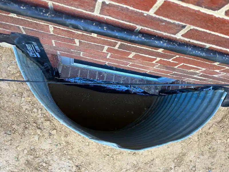Basement window well area with drainage foundation protection, before turf installation.