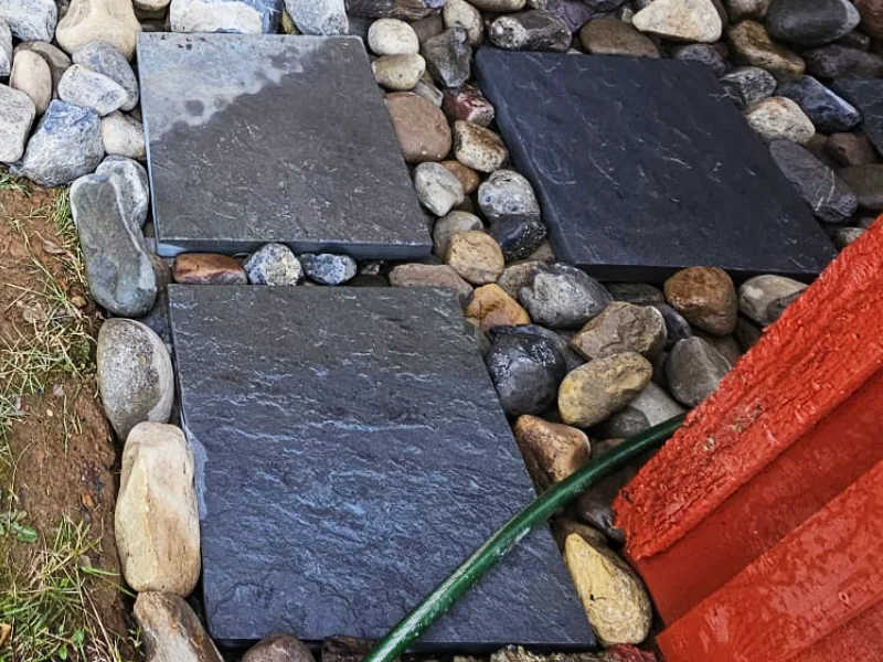 Large stepping stones installed between two historic barns to create a stable walkway across the drainage swale area.