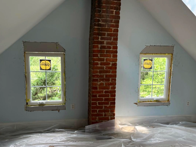 Newly installed attic window before drywall repairs, trim installation, and final painting.