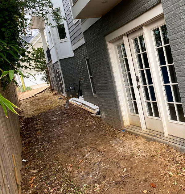 Finished side yard with river rock drainage, natural flagstone stepping stones, and improved access along the side of the home.